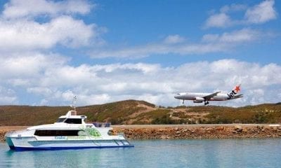 a plane flying over a boat in the water.