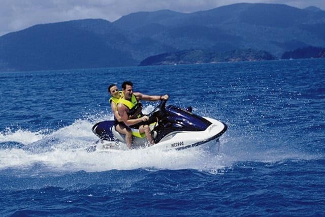 two people on a jet ski in the ocean.