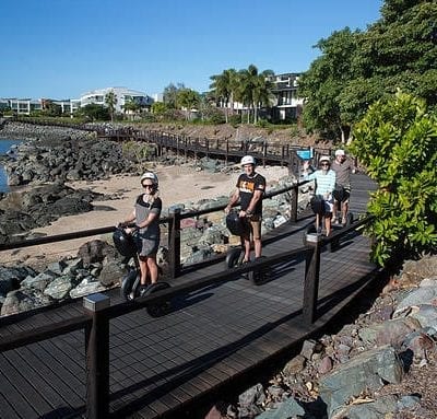 a group of people riding bikes across a bridge.